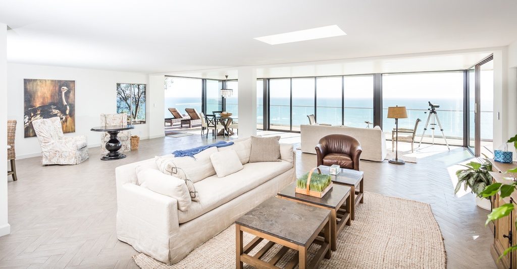 Living area with couches and large windows.