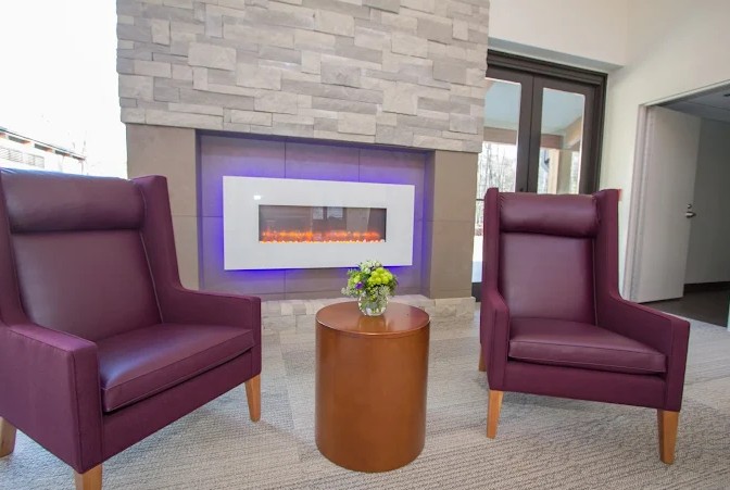Cozy seating area with chairs and wall fireplace