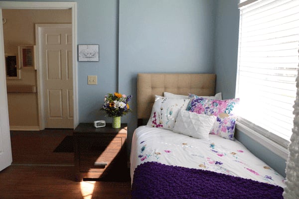 Bright bedroom with floral bedding and bedside table