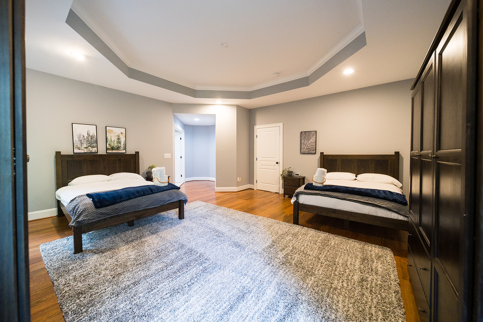 Spacious room with two beds and dark wood furniture