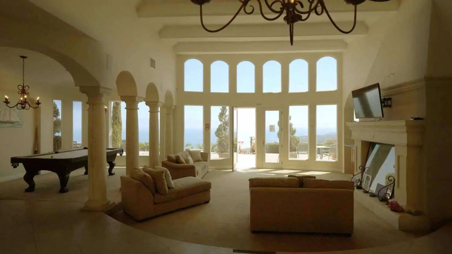 Open common area with sofas, fireplace, and tall windows