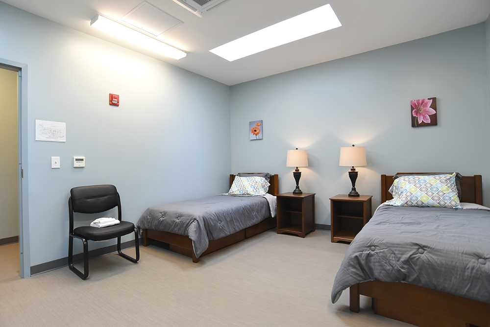 Two-bed patient room with lamps and chairs