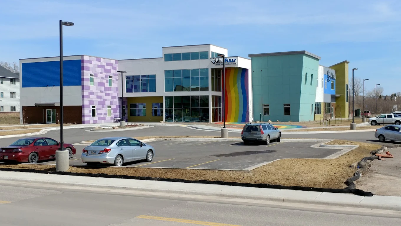 Colorful facility exterior with rainbow mural and parking lot