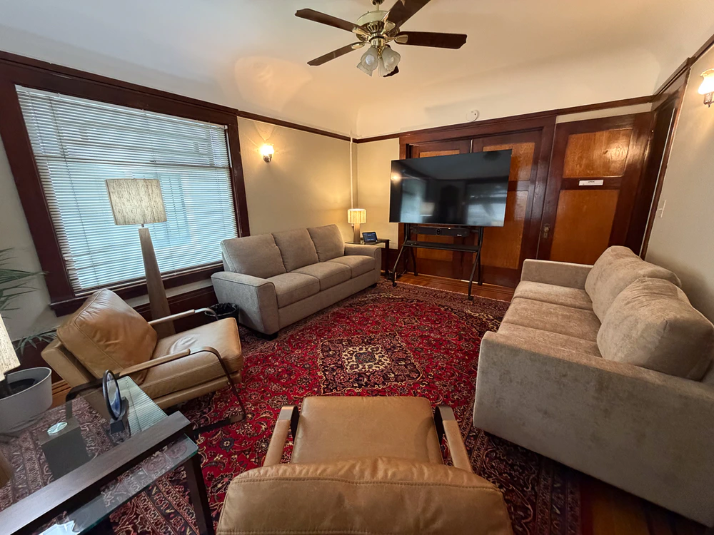 Group therapy lounge with sofas and large TV