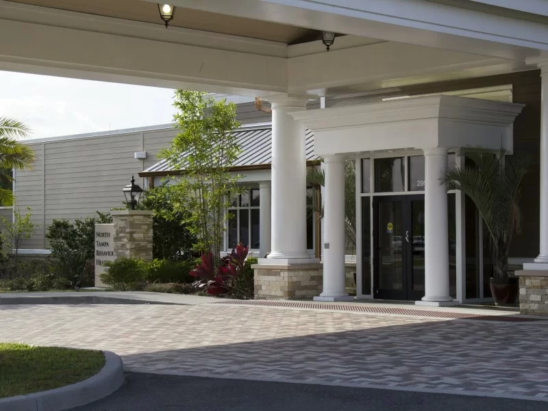 Covered entrance with white columns and glass doors