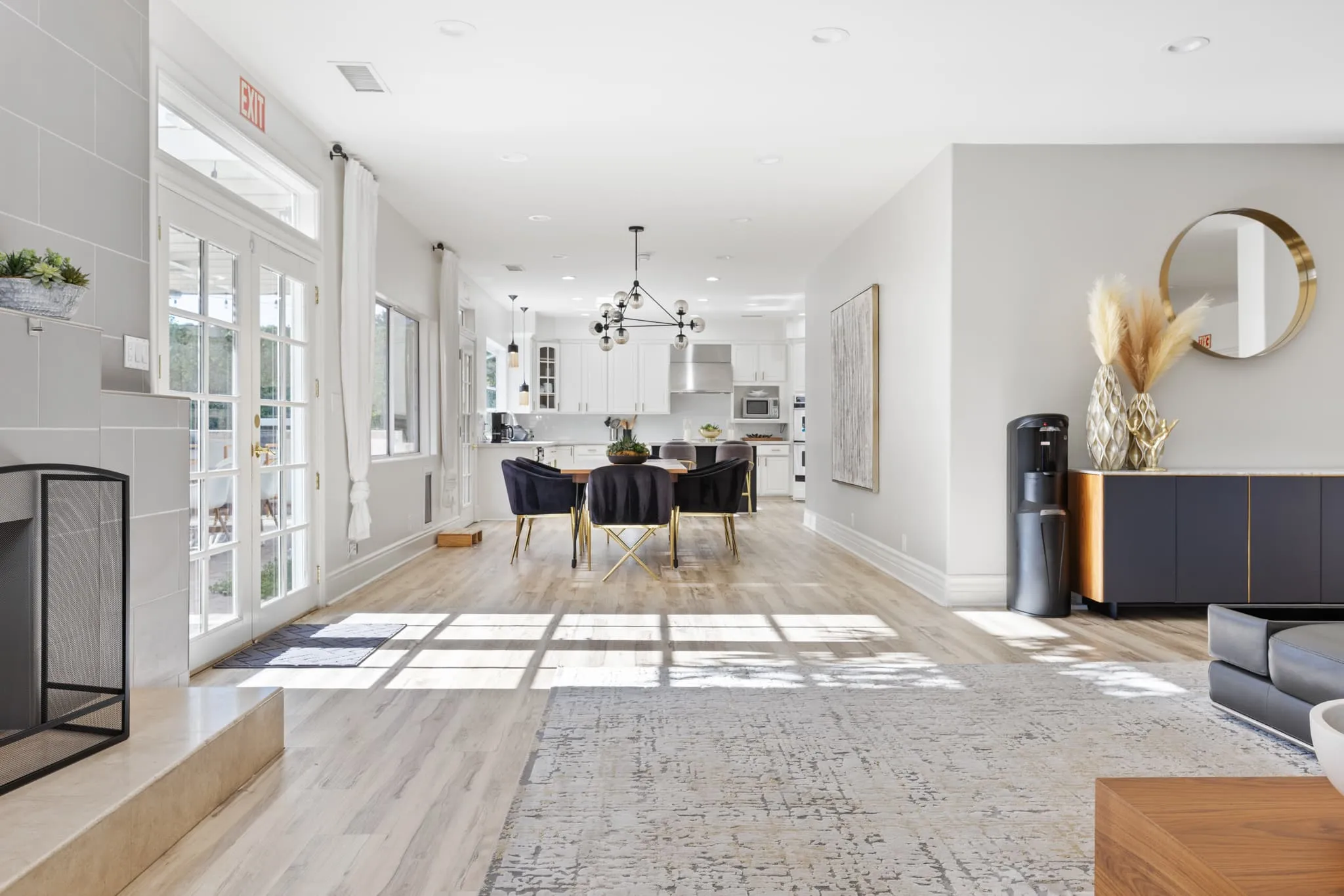 Elegant dining area with chandelier and view into kitchen.