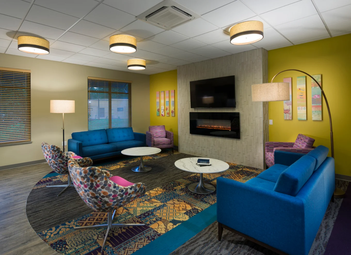 Colorful lounge with sofas, television, and fireplace