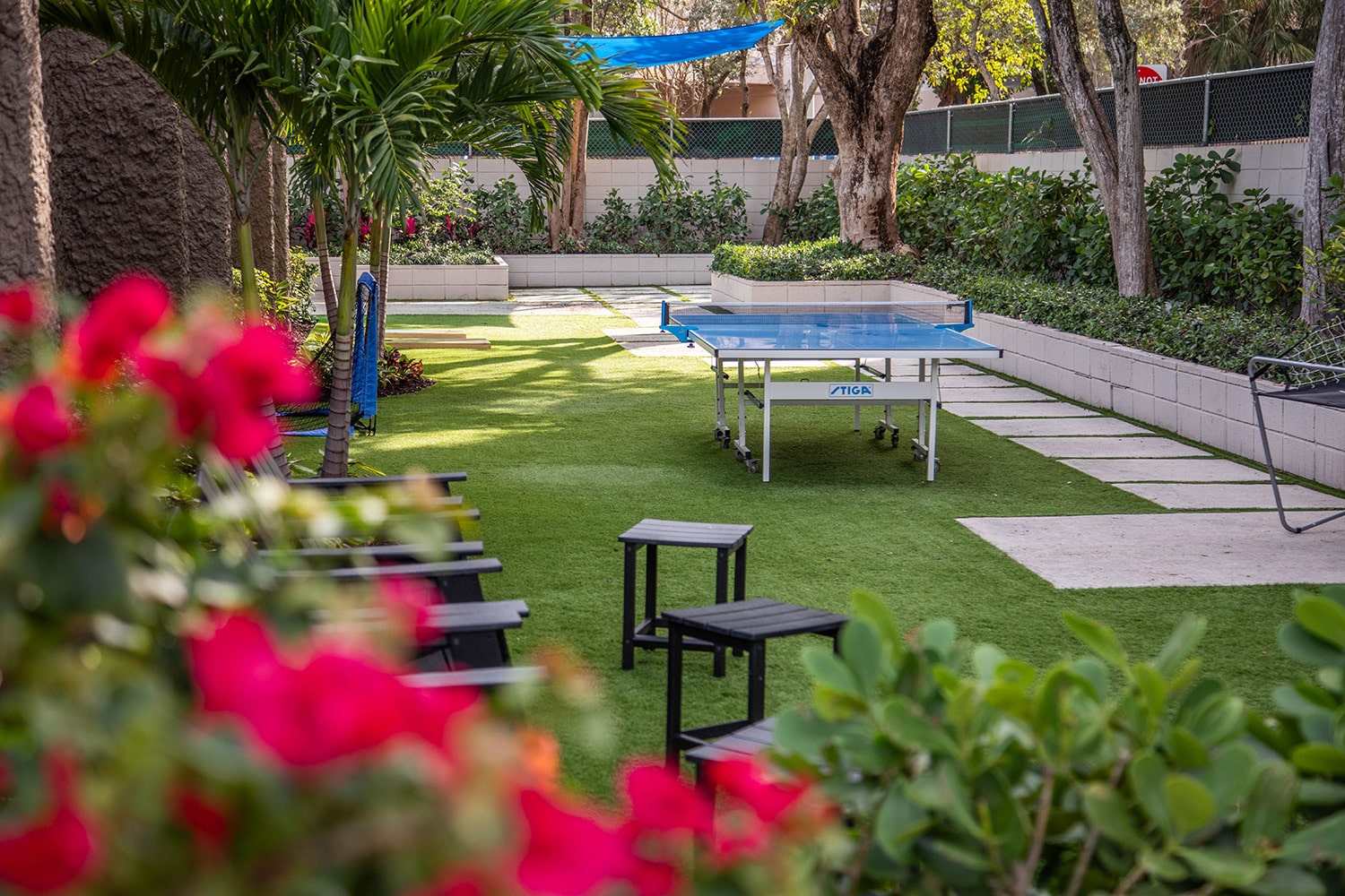 Lawn with ping pong table, palm trees, and seating area