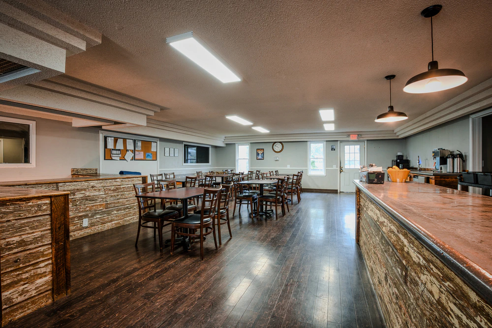 Spacious dining hall with multiple tables and a serving counter