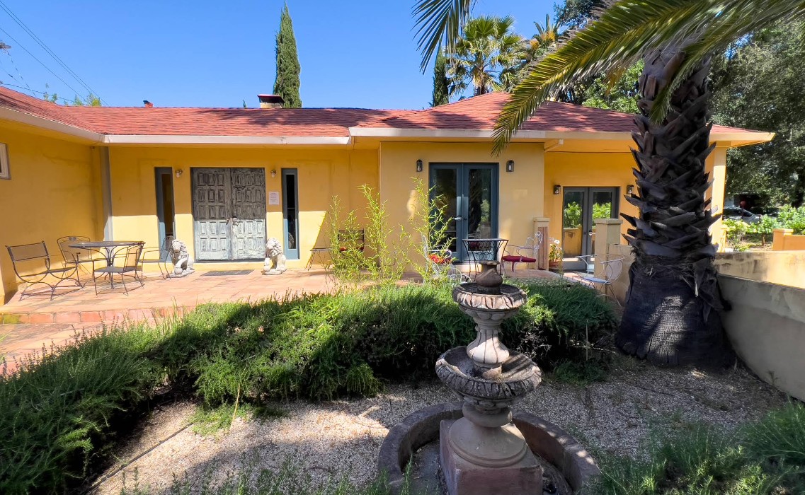 Courtyard with fountain, patio seating, and palm tree