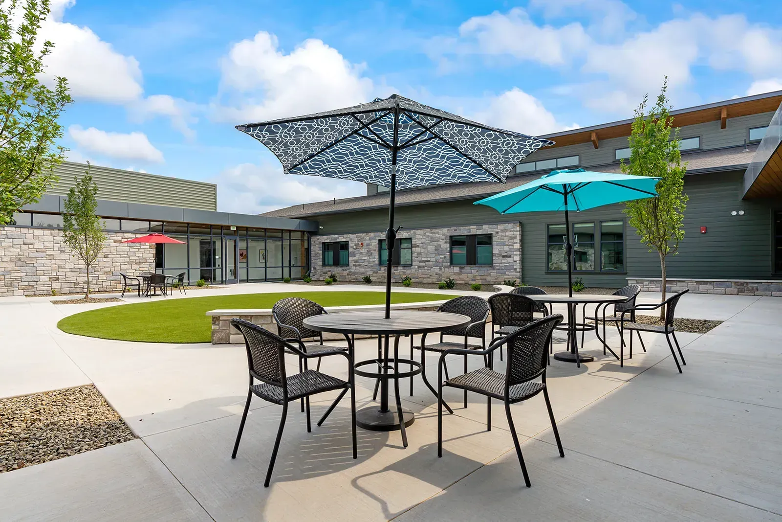 Outdoor courtyard seating with shaded tables and lawn