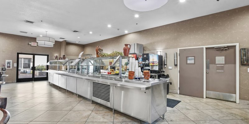 A clean, spacious cafeteria with a modern buffet setup, bright lighting, and a welcoming environment for enjoying nutritious meals.