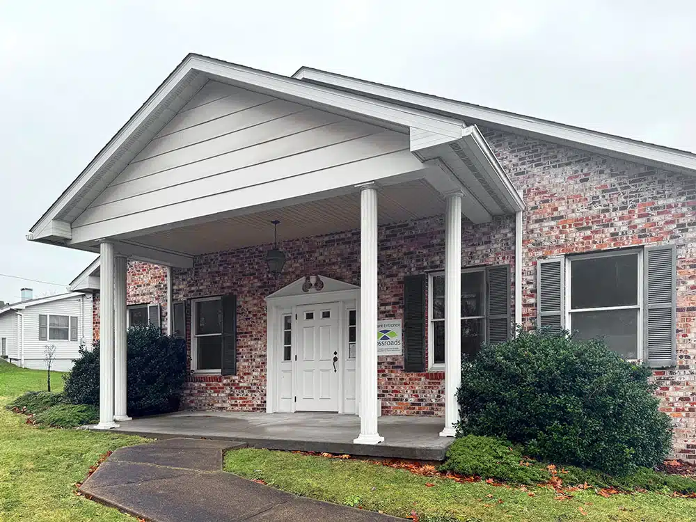 Brick building entrance with white columns and covered porch