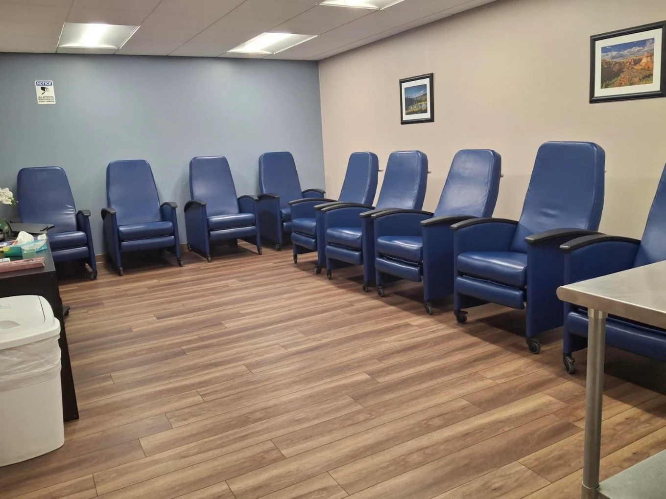 Treatment room with rows of blue reclining chairs