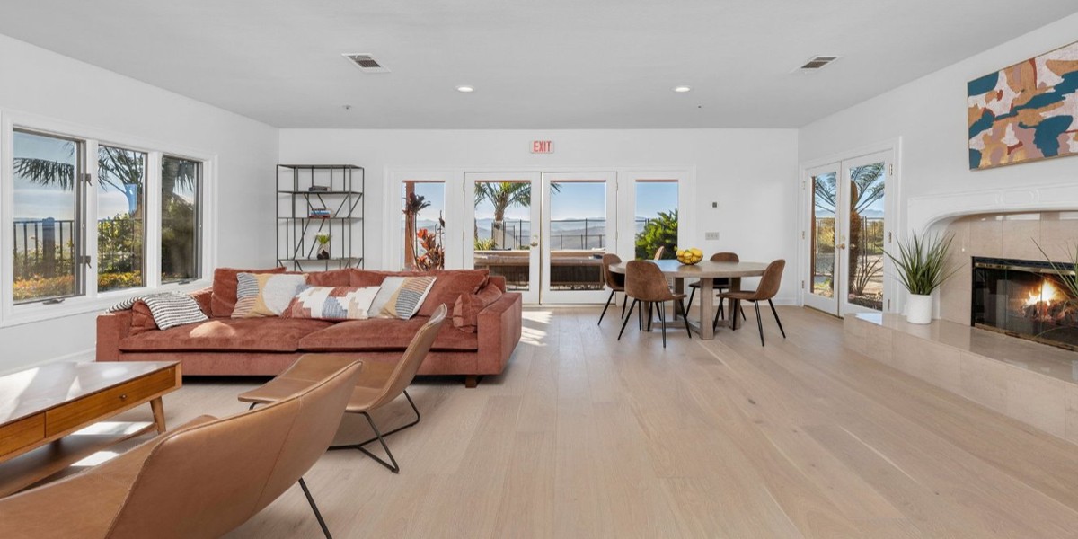 Bright lounge with sofa, fireplace, and ocean view