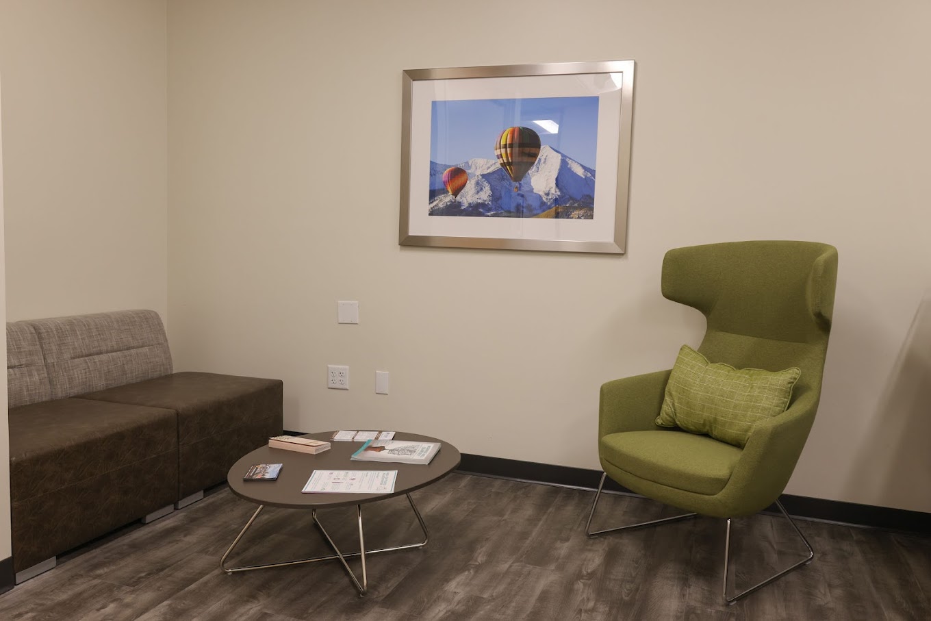 Therapy room with green and brown seating and a framed artwork.