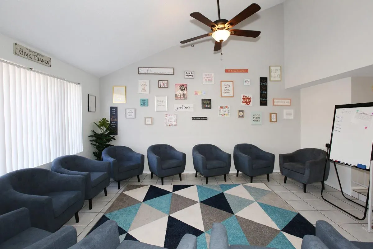 Group meeting room with circle seating and whiteboard at Sanctuary Sober Living Rose Garden