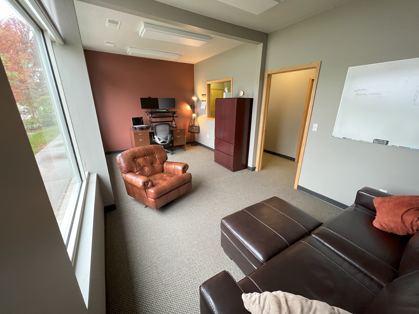 Therapy office with leather seating and office setup