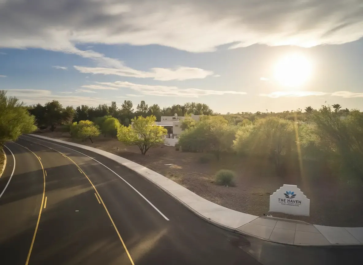 Roadside facility sign with trees and sunset in background.