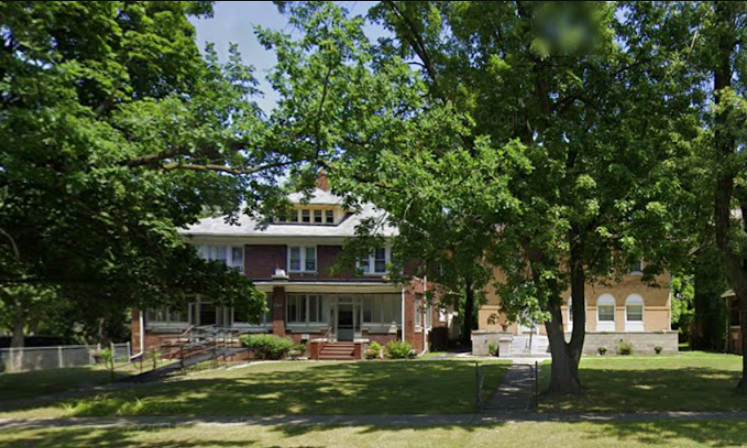 Brick residential rehab home with porch and large front yard