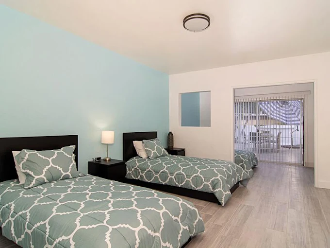 Shared bedroom with twin beds and patio access