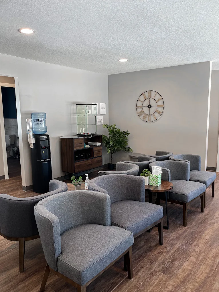 Lounge with armchairs, tables, and beverage station