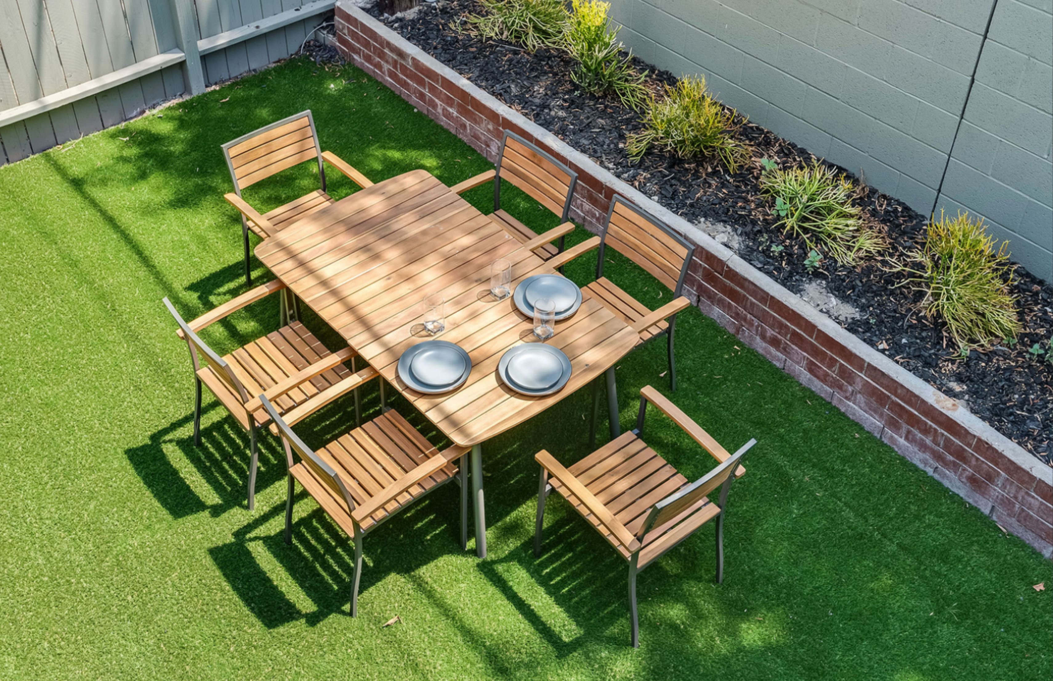Outdoor dining setup with wooden table and chairs.