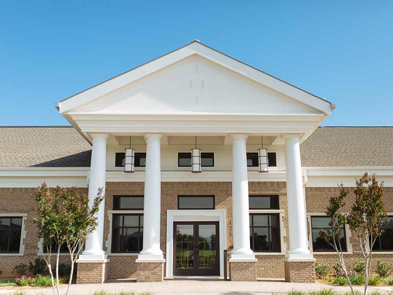 Front entrance of Mount Regis Center addiction treatment facility with white columns and brick exterior