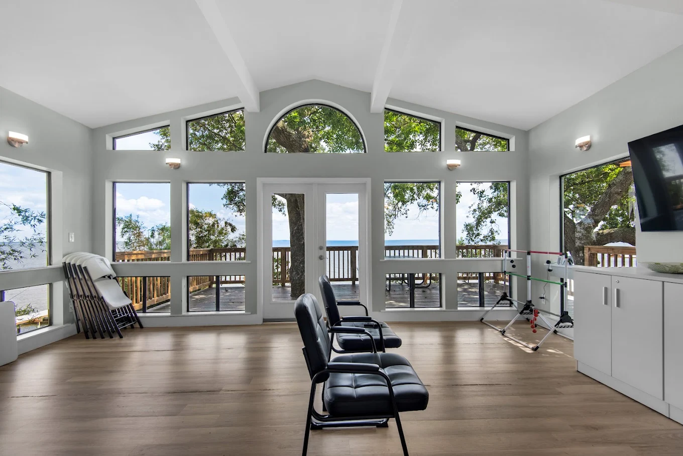 Recreation room with chairs, TV, and waterfront windows