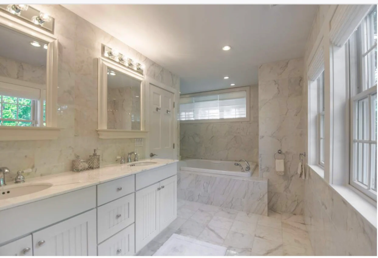 Marble bathroom with double sinks and soaking tub