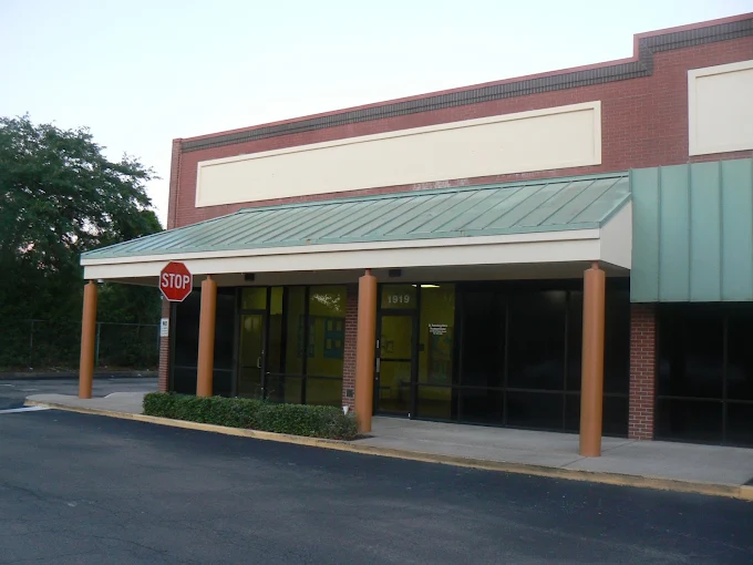 Brick treatment center entrance with covered walkway and stop sign