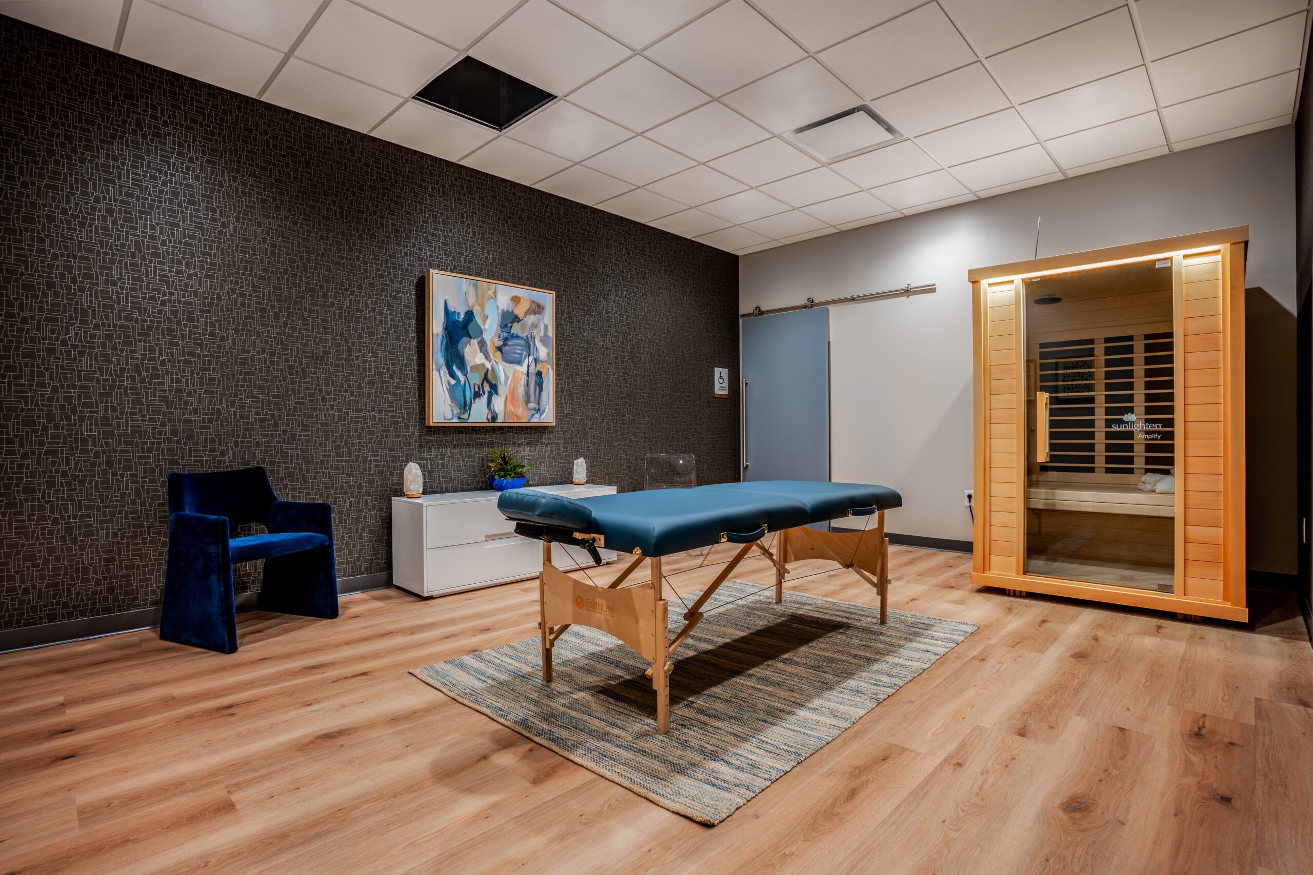 Massage room with treatment table and infrared sauna