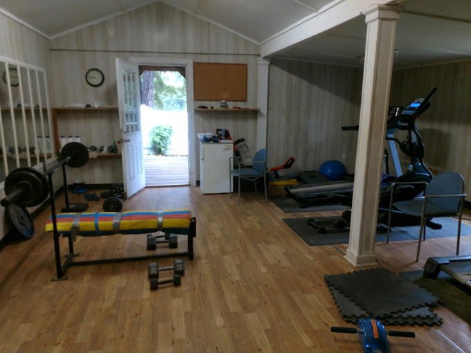 Fitness room with exercise equipment at ACE Recovery for Men in Chesterfield