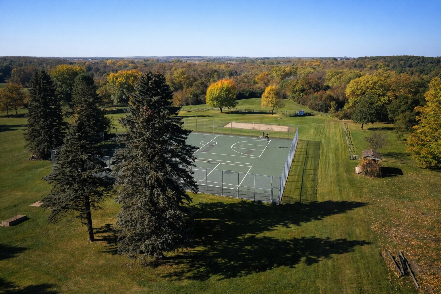Aerial view of outdoor sports court surrounded by trees.