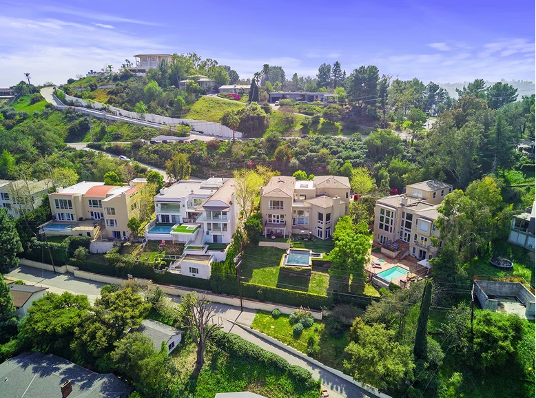 Hillside aerial view of Red Door Life residential property with pool and greenery