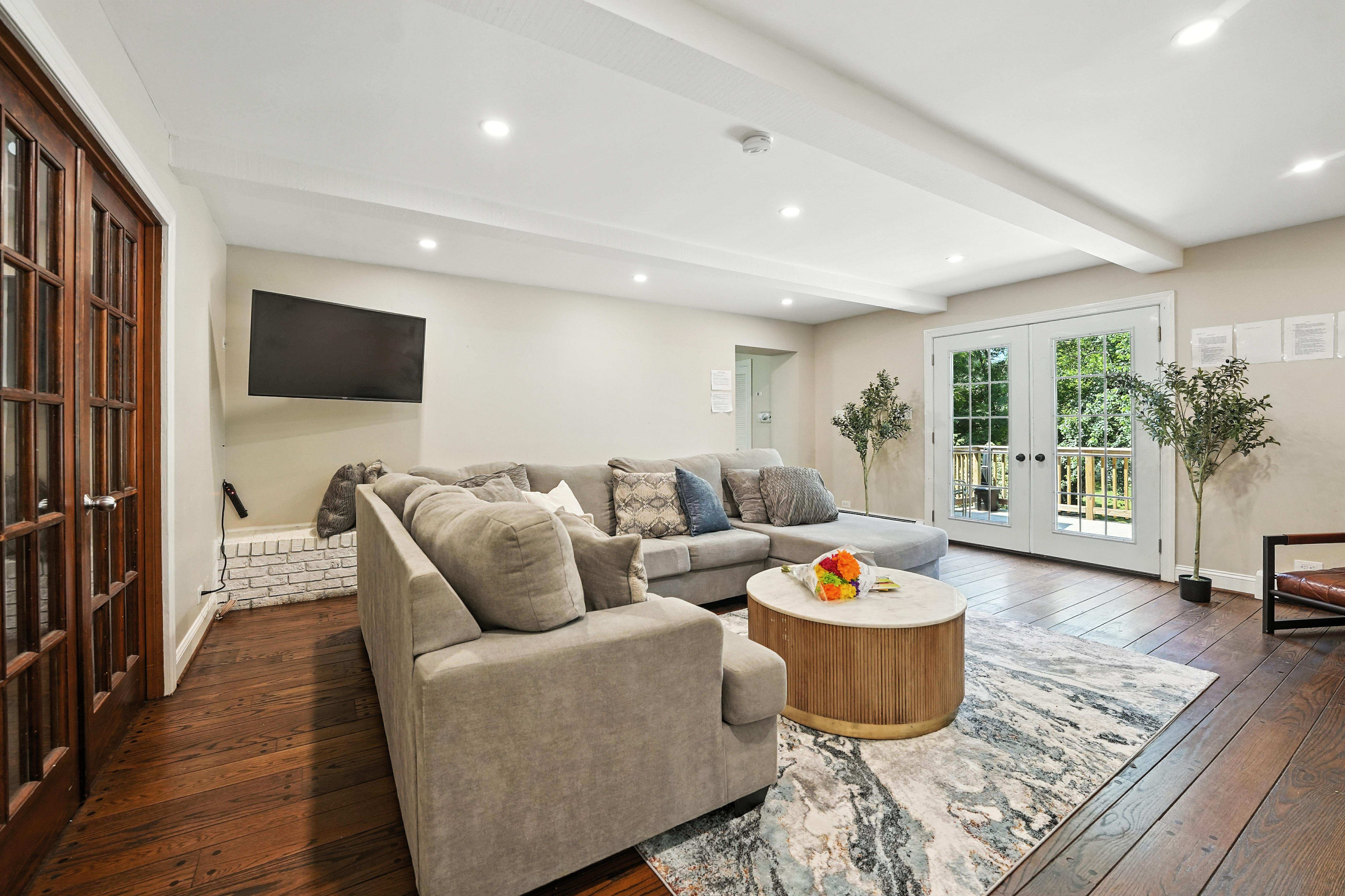 Living room with sectional sofa, TV, and French doors