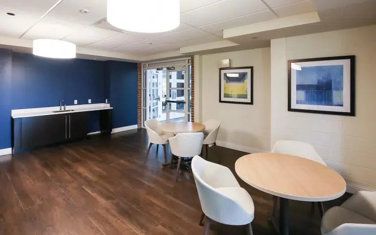 Common area with round tables, chairs, artwork, and counter