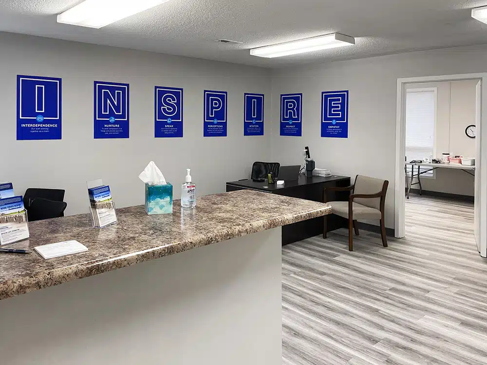 Reception desk with hand sanitizer and Inspire posters