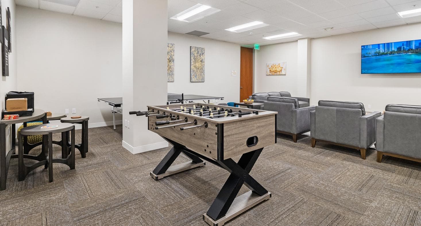 Recreation room with foosball, ping-pong, and lounge seating.