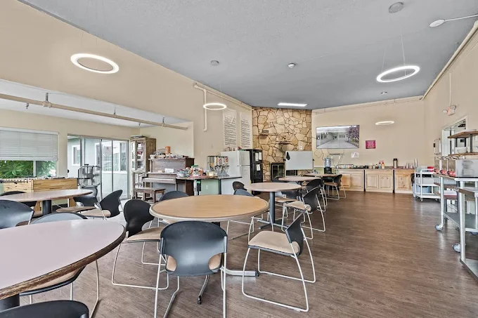 Open dining space with round tables and kitchen