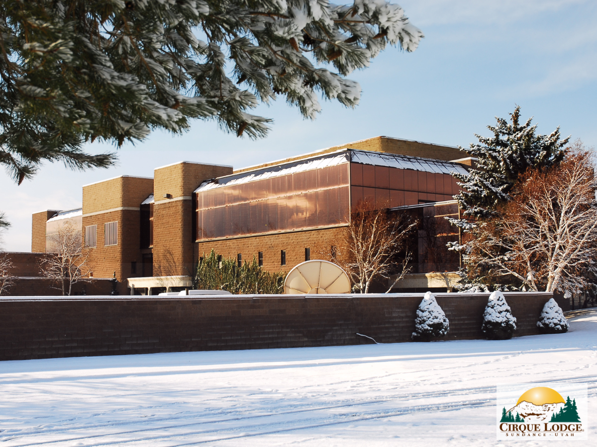 Snow-covered rehab facility building with trees in winter