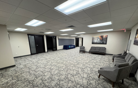 Spacious community lounge with seating and open floor area
