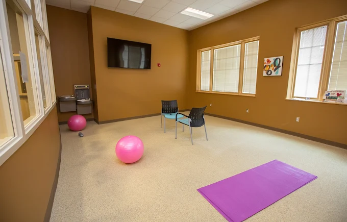 Exercise room with yoga mats, fitness balls, and TV