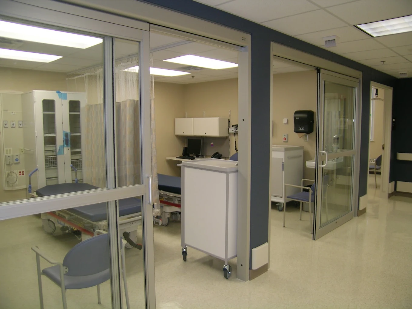 Glass-partitioned medical area with chairs and equipment