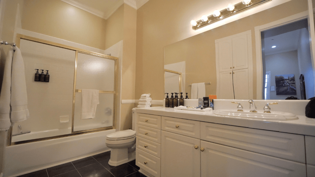 Bathroom with double vanity, bathtub, shower, and towels