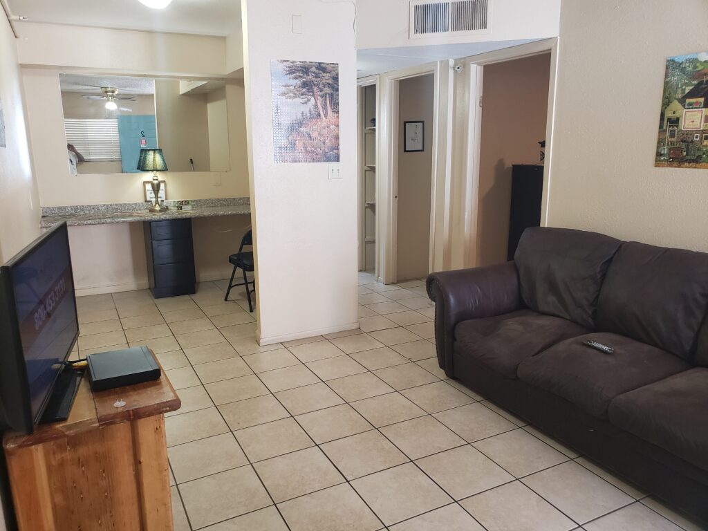 Living room with couch, TV, and tiled floors