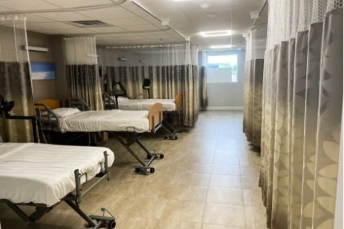 Room with several hospital beds and curtains