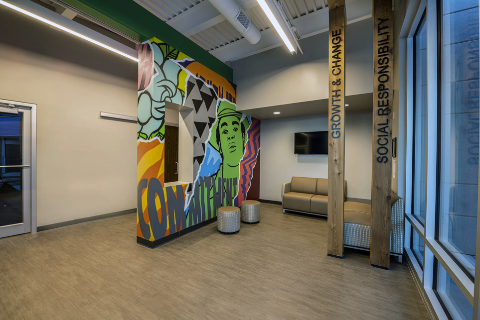 Lobby with colorful mural, seating, and large windows