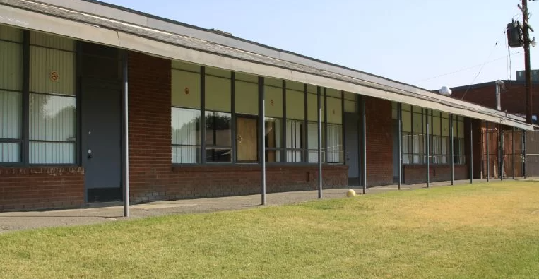 Long brick building with windows and covered walkway