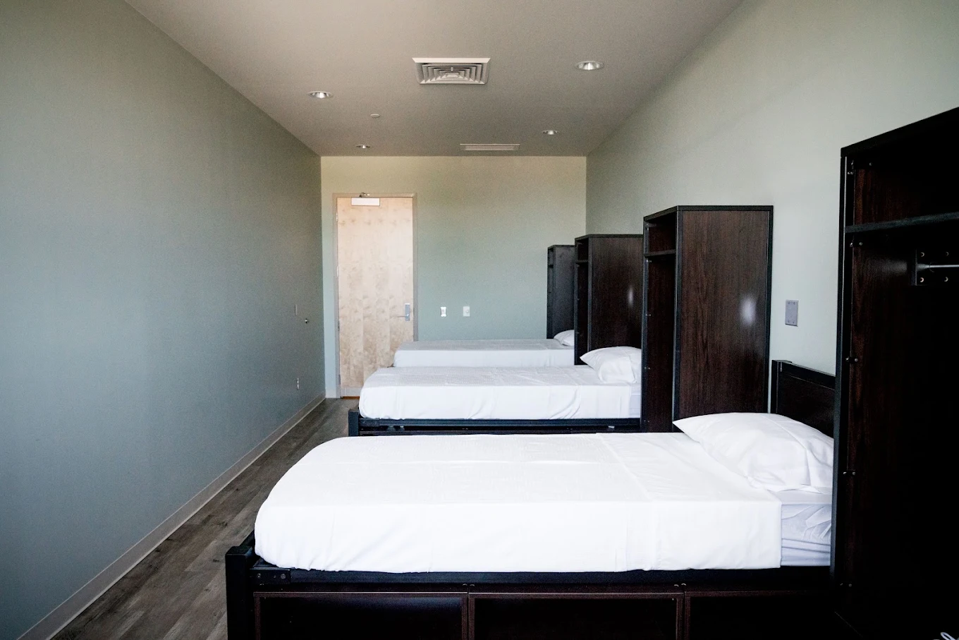 Shared bedroom with two beds, white bedding, and dark furniture